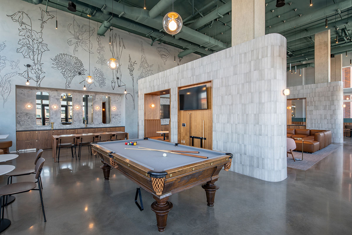 Clubroom lounge with pool table, demo kitchen, and comfortable dining area.