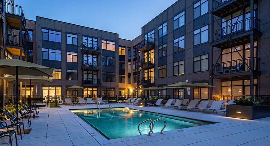 Pool area with lounge chairs, umbrellas, and potted plants.